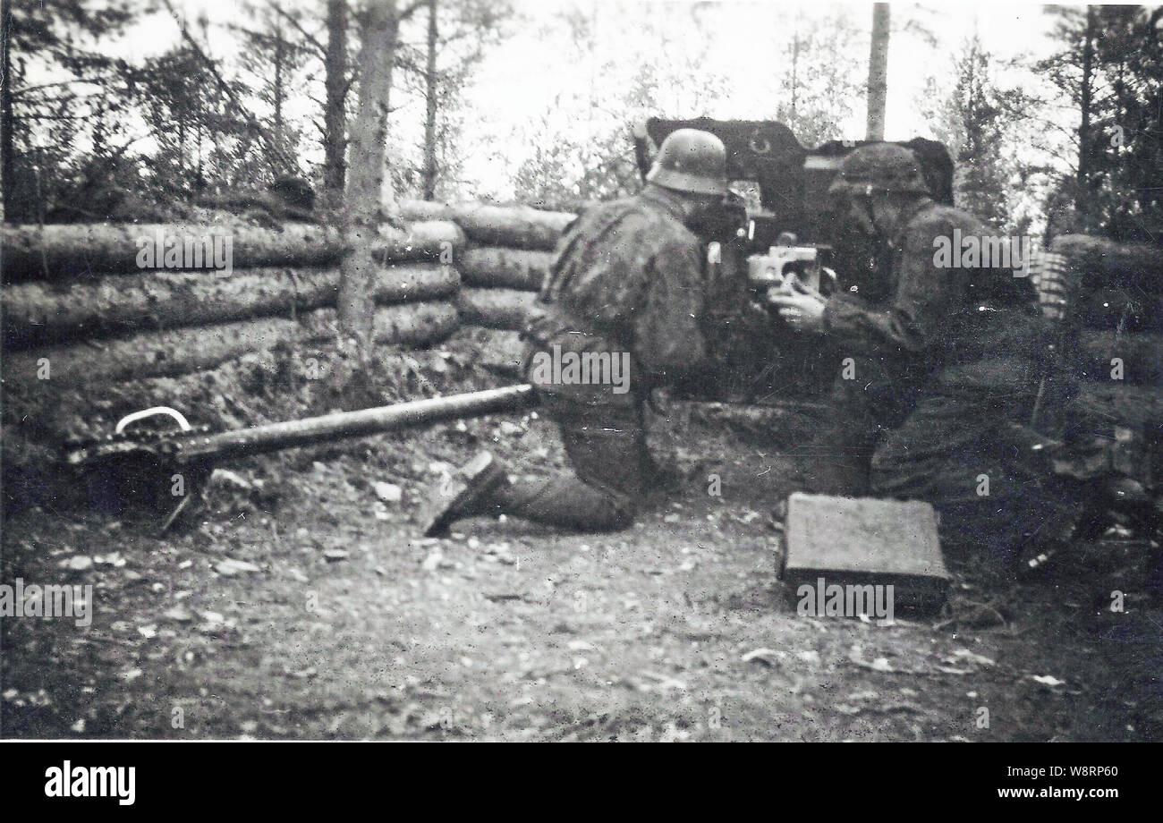 Deutsche Soldaten in der Tarnung Kittel in der 6. SS Mountain Division Nord mit einem leichten Pak Pak in der Defensive Position an der russischen Front Stockfoto