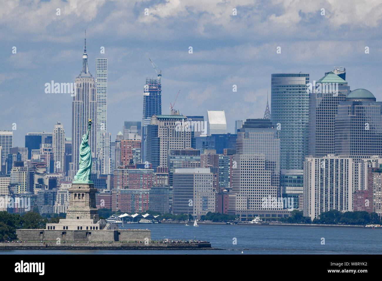 Freiheitsstatue & Skyline von New York City Manhattan im Hintergrund - Freiheit, Symbol der Ellis Island - Empire State Building im Sommer Haze Stockfoto