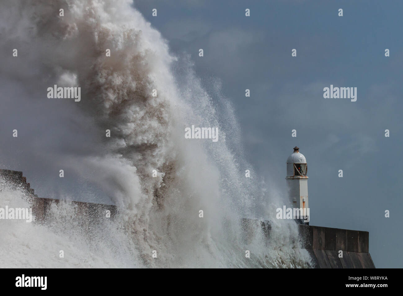 Riesigen Ozean Wellen in ein Meer von Wand- und Leuchtturm (Porthcawl, South Wales, UK) Stockfoto