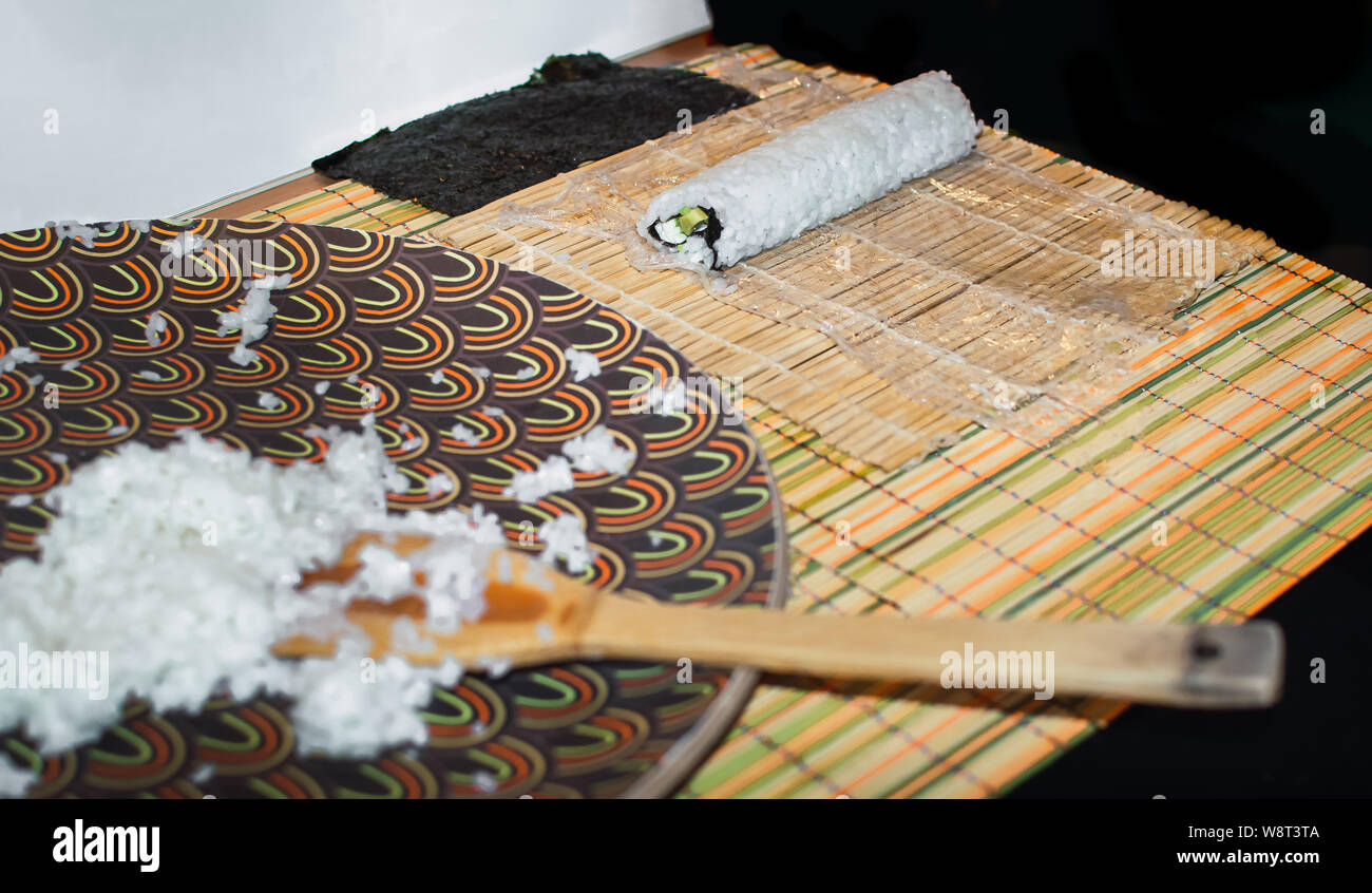 Die Sushi in einem japanischen Küche mit orientalischen und traditioneller Dekoration. Prozess, Sushi, Sushi Roll mit Gemüse, Ansicht von oben. Stockfoto