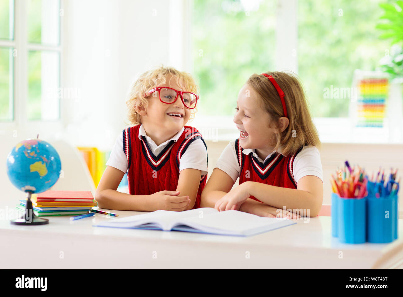 Kinder gehen wieder zur Schule. Kinder Studieren und Lernen für Vorschulkinder. Jungen und Mädchen der Grundschule klasse Hausaufgaben machen. Schlafzimmer mit Schreibtisch, Bücher und Globus fo Stockfoto