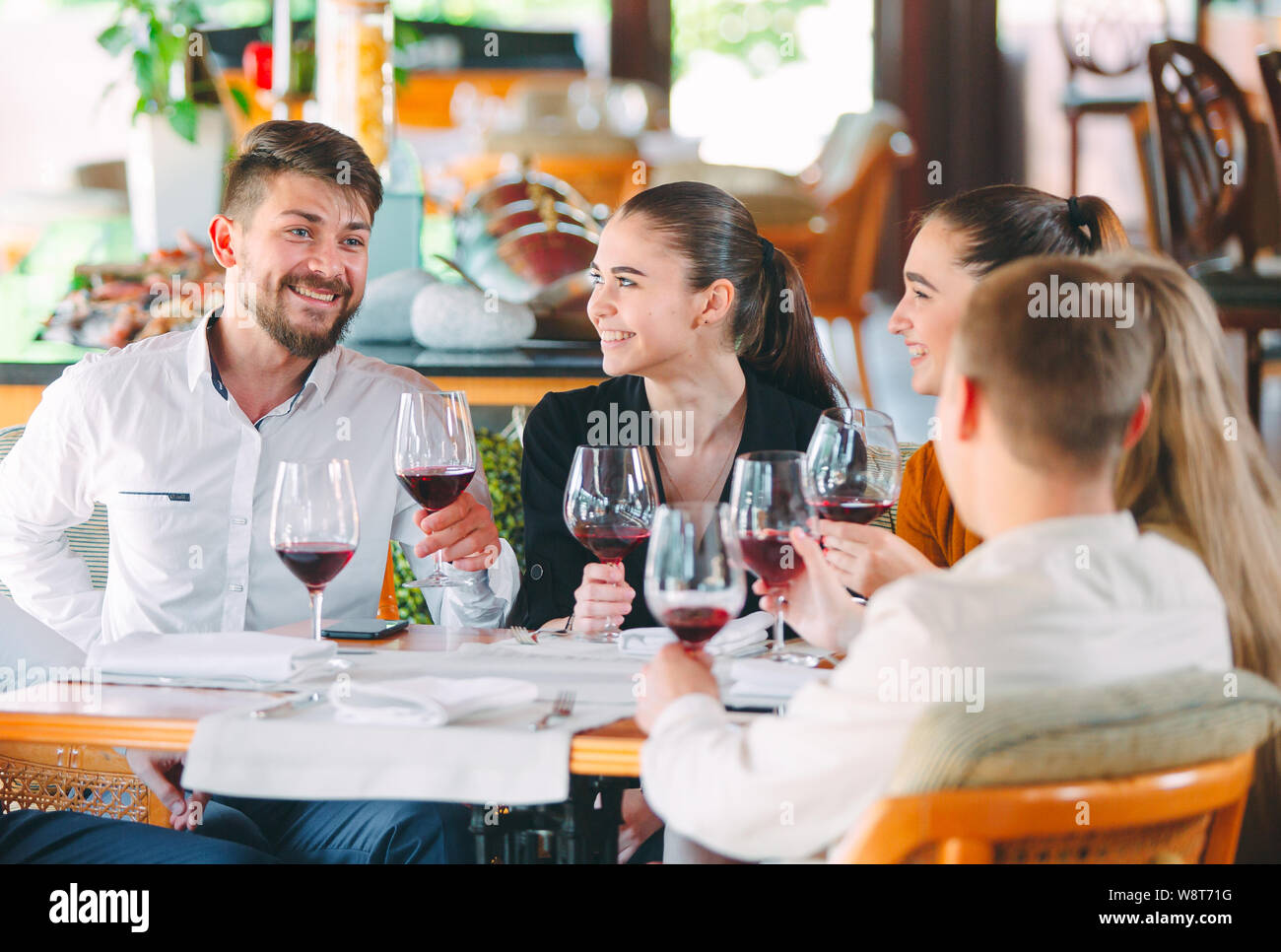 Freunde trinken Wein auf der Terrasse des Restaurants. Stockfoto