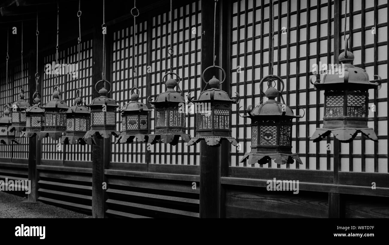 Gruppe der traditionellen bronze Laternen hängen vom Dach der Schrein der Gebäude in Naras Kasuga Taisha liefern ein Muster, Japan, November 2018 Stockfoto