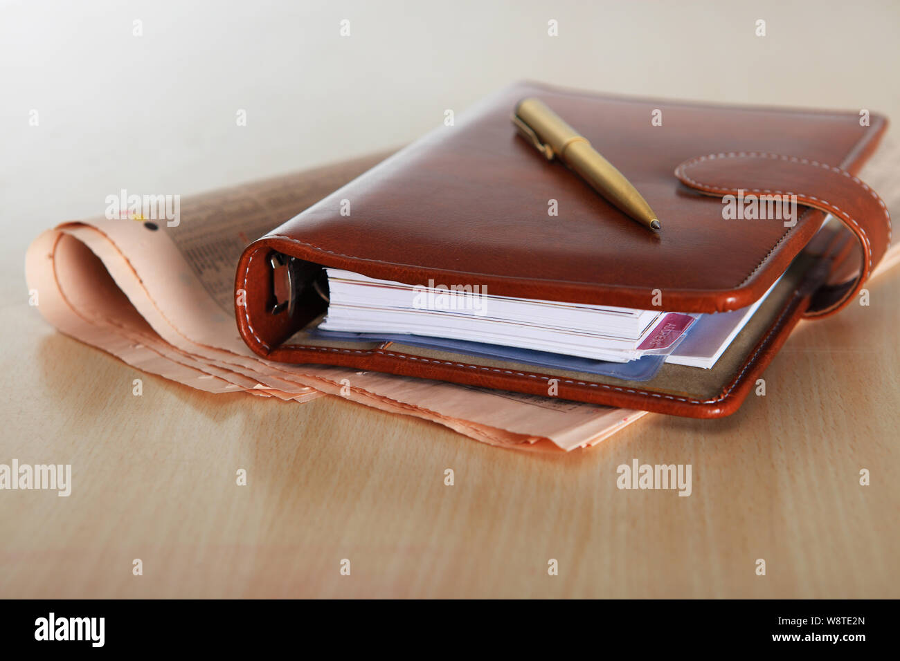 Terminplaner und Stift auf einer Finanzzeitung Stockfoto