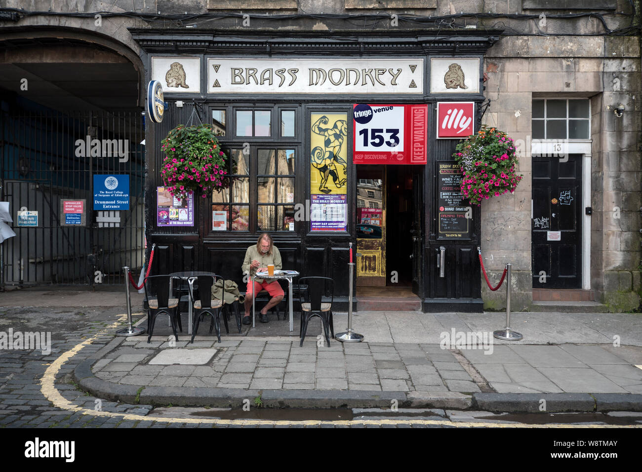 Eine touristische entspannt sich mit einem Pint außerhalb des Brass Monkey in Drummond Street - auch öffentlichen Häusern Schauplätze während des Edinburgh Fringe Festival geworden! Stockfoto