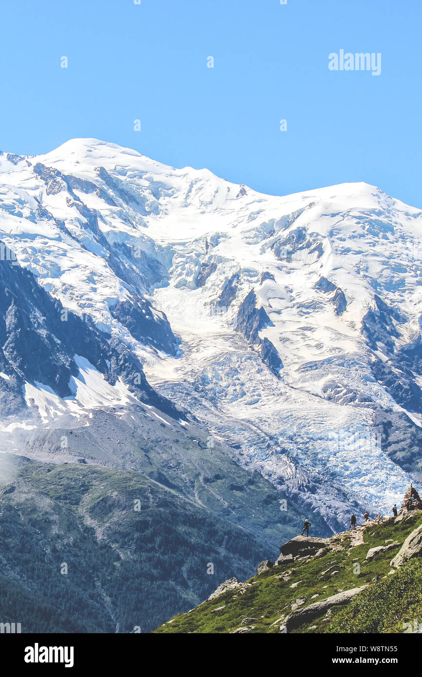 Wanderer oben auf einem Felsen mit Blick auf die erstaunliche Mont Blanc in den Alpen, in der Nähe von Chamonix, Frankreich. Höchster Gipfel der Französischen Alpen und Europa. Sommer Saison. Abenteuer, Wandern Konzept. Touristische Orte. Stockfoto