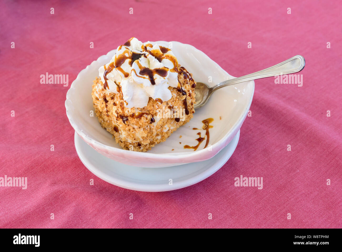 Italienische Eis Dessert mit Topping und Schlagsahne auf dem rosa Tischdecke Stockfoto