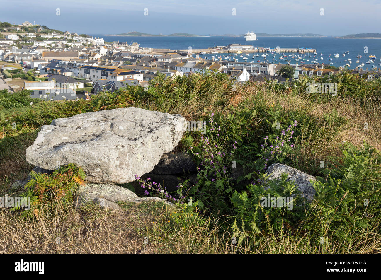 Blick von buzza Hill gegen Hugh Stadt und den Hafen, mit einem jungsteinzeitlichen Grabkammer (Dolmen) im Vordergrund, die St Mary's, Isles of Scilly Stockfoto
