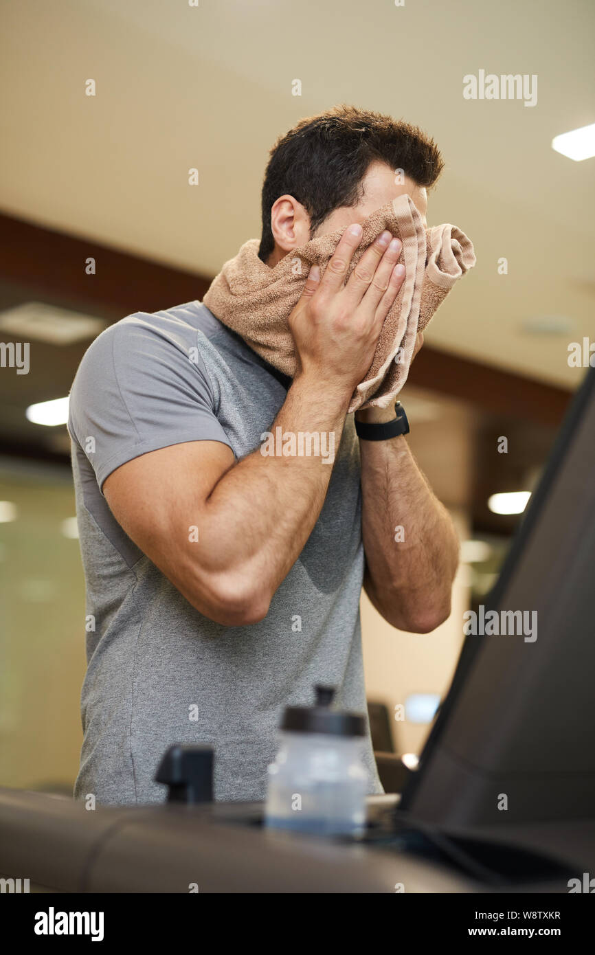 Taille bis Portrait von stattlicher Mann v auf Laufband im Fitnessstudio und Abwischen Gesicht mit Handtuch, Kopie Raum Stockfoto