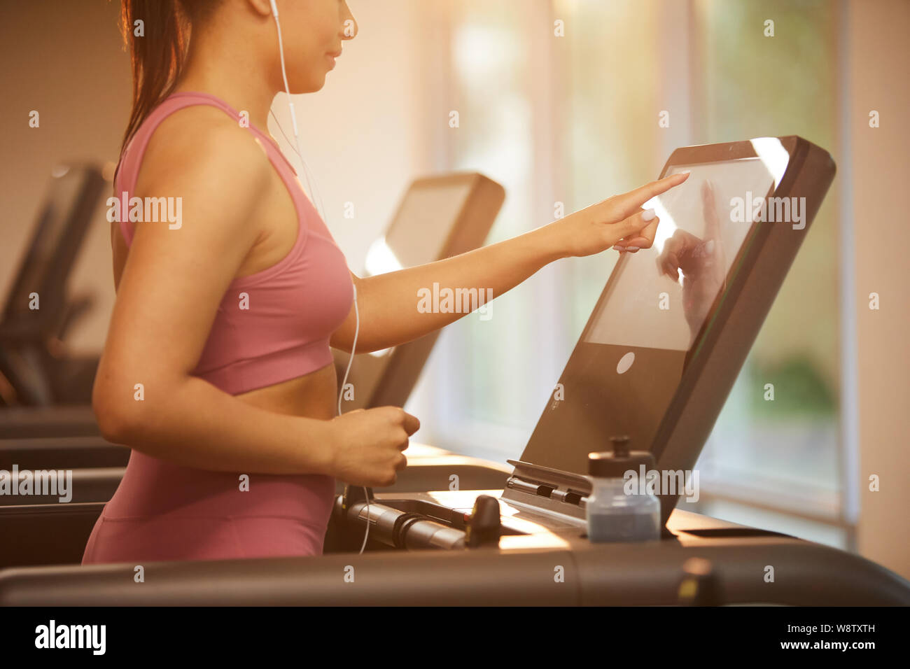Seitenansicht Porträt der schönen jungen Frau, die auf Laufband im Fitnessstudio während cardio Workout, Kopie Raum Stockfoto