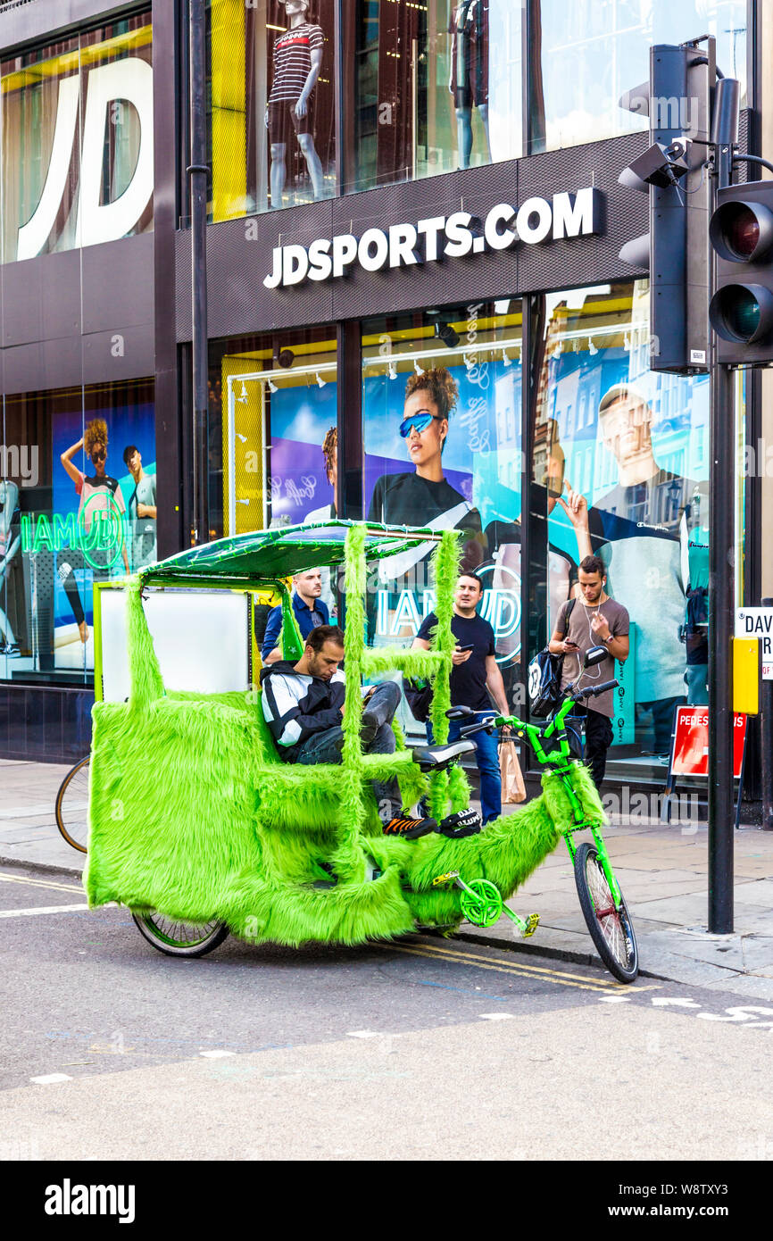 Eine Rikscha mit grünem Fell in der Nähe der Oxford Street in London, Großbritannien Stockfoto
