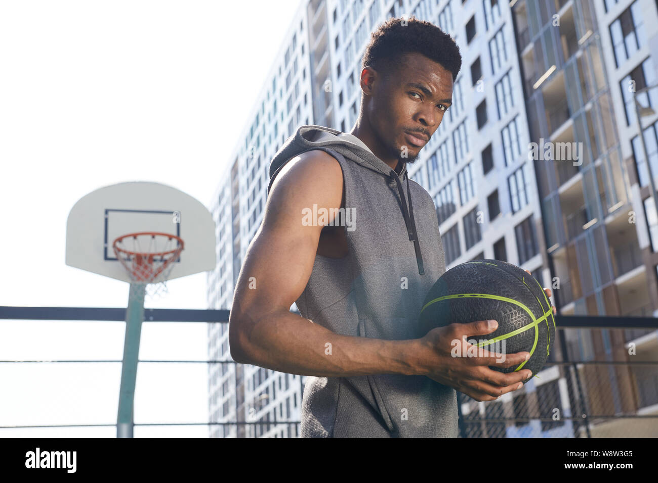 Taille bis Portrait von stattlichen Afrikaner - Mann mit Basketball Ball und bei Camera zuversichtlich, kopieren Raum Stockfoto