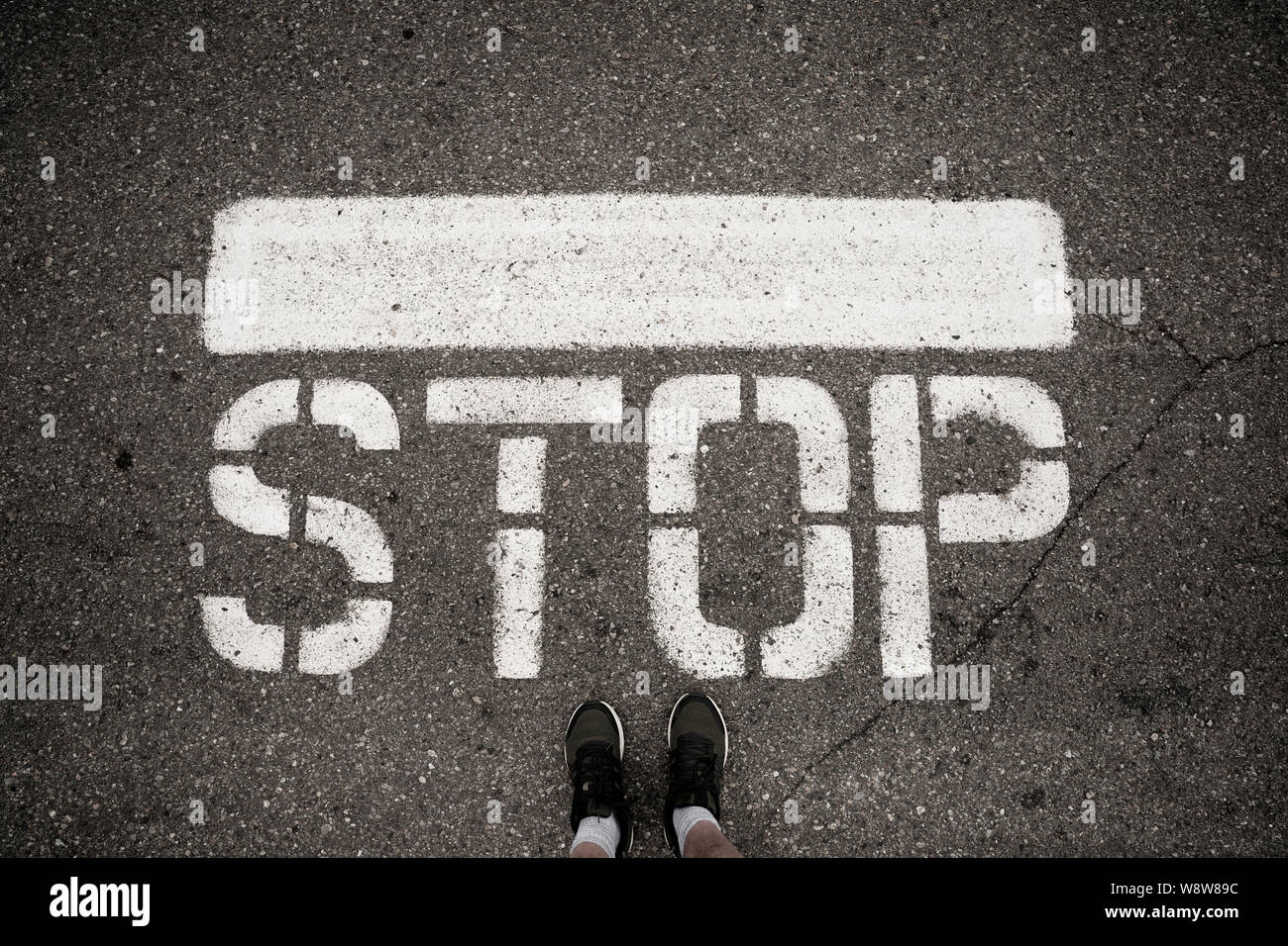 Stop-Schild auf dem Boden vor FEETS Stockfoto
