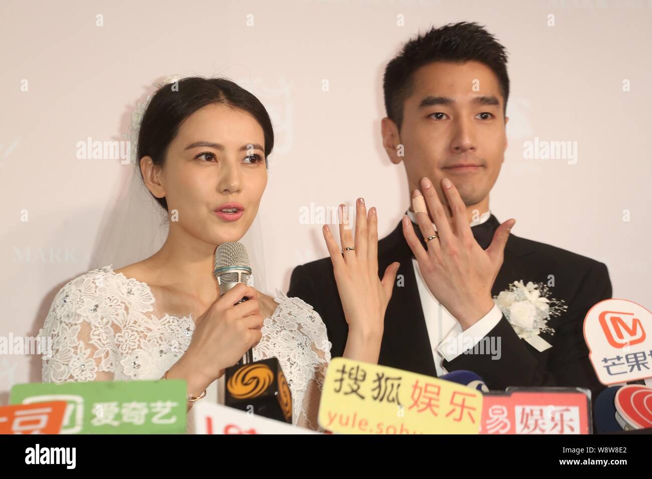 Chinesische Schauspielerin Gao Yuanyuan, Links, und ihre taiwanesischen Schauspieler Mann Mark Chao zeigen Ihre Trauringe während ihrer Hochzeit Bankett in Taipei, Taiwan, Stockfoto