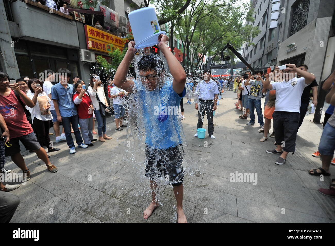 Junge Leute richten entlang einer Straße den Eimer für das Eis Herausforderung in Zhongguancun, tapfer, auch als China's Silicon Valley, in Peking, China, 21. August bekannt Stockfoto