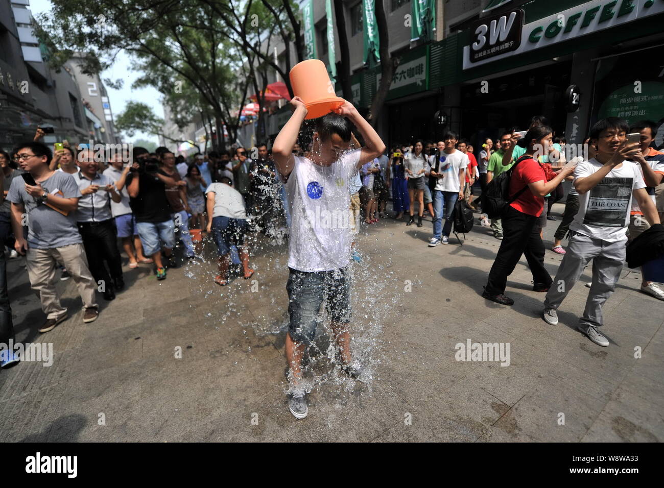 Junge Leute richten entlang einer Straße den Eimer für das Eis Herausforderung in Zhongguancun, tapfer, auch als China's Silicon Valley, in Peking, China, 21. August bekannt Stockfoto