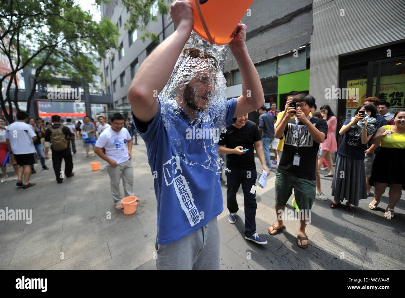 Junge Leute richten entlang einer Straße den Eimer für das Eis Herausforderung in Zhongguancun, tapfer, auch als China's Silicon Valley, in Peking, China, 21. August bekannt Stockfoto