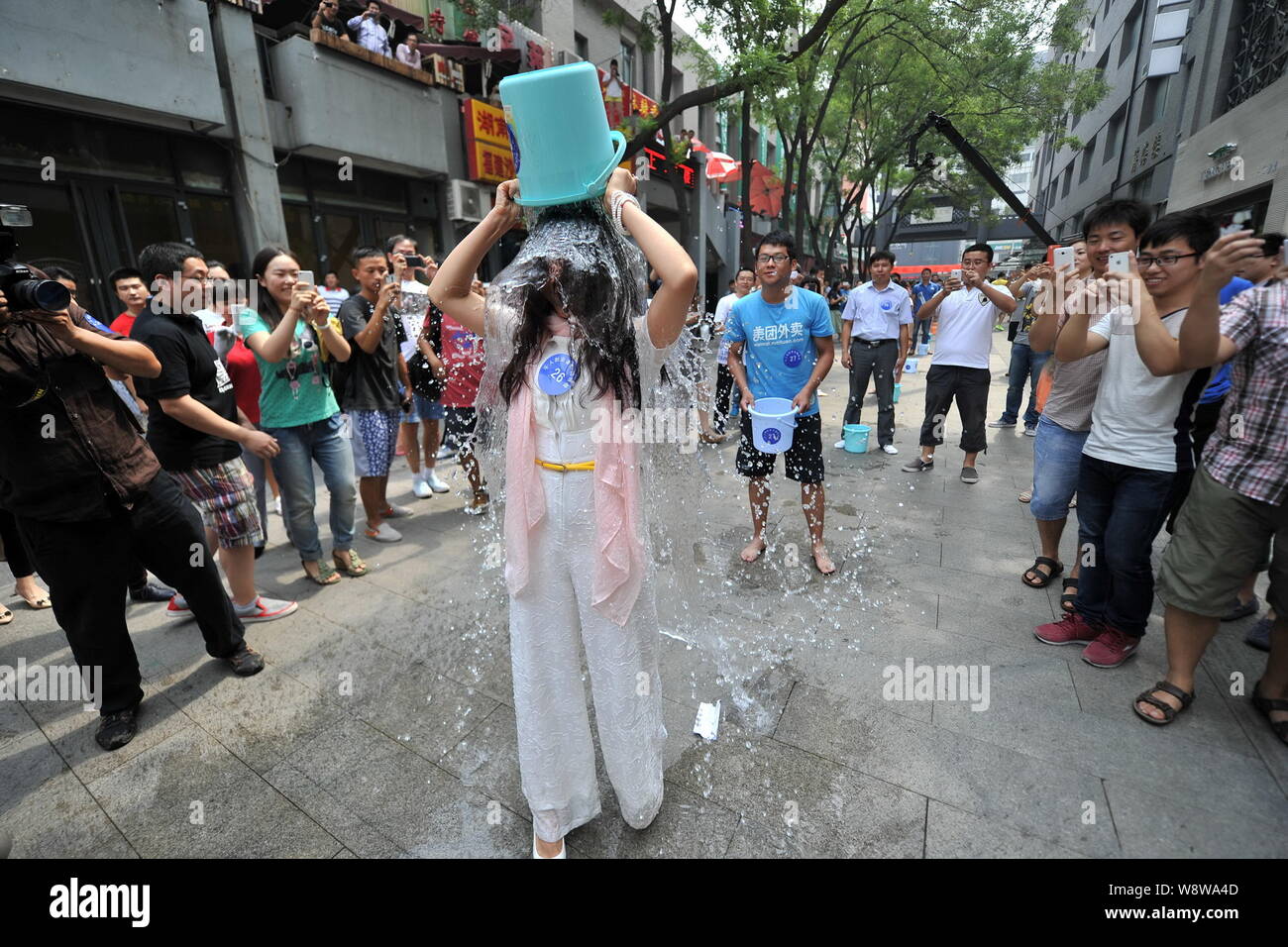 Junge Leute richten entlang einer Straße den Eimer für das Eis Herausforderung in Zhongguancun, tapfer, auch als China's Silicon Valley, in Peking, China, 21. August bekannt Stockfoto