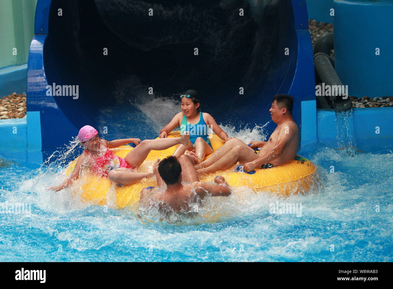 ---- Urlauber sitzen in einem aufblasbaren Floß wie Rafting in einem Indoor Water Park am National Aquatics Center genießen, auch als das Wasser bekannt Stockfoto