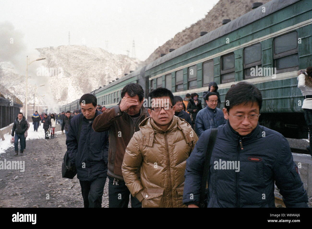 ---- Passagiere durch eine "grüne Haut" Zug, als Sie zu Fuß towwards der Ausfahrt der Sanyanlian Bahnhof in Baiying Stadt im Nordwesten Chinas Ga Stockfoto