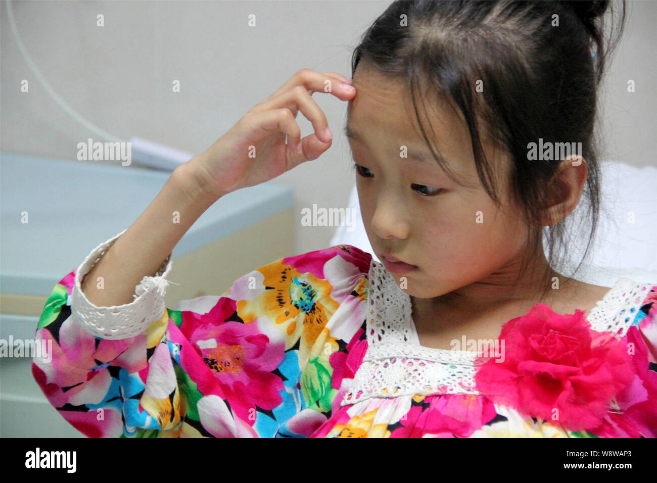12-jährige Mädchen Han Bingbing wer leidet unter einem riesigen Tumor im Bauch auf dem Bett bei Fuda Krebs Krankenhaus in Guangzhou City sitzt, South China Guan Stockfoto