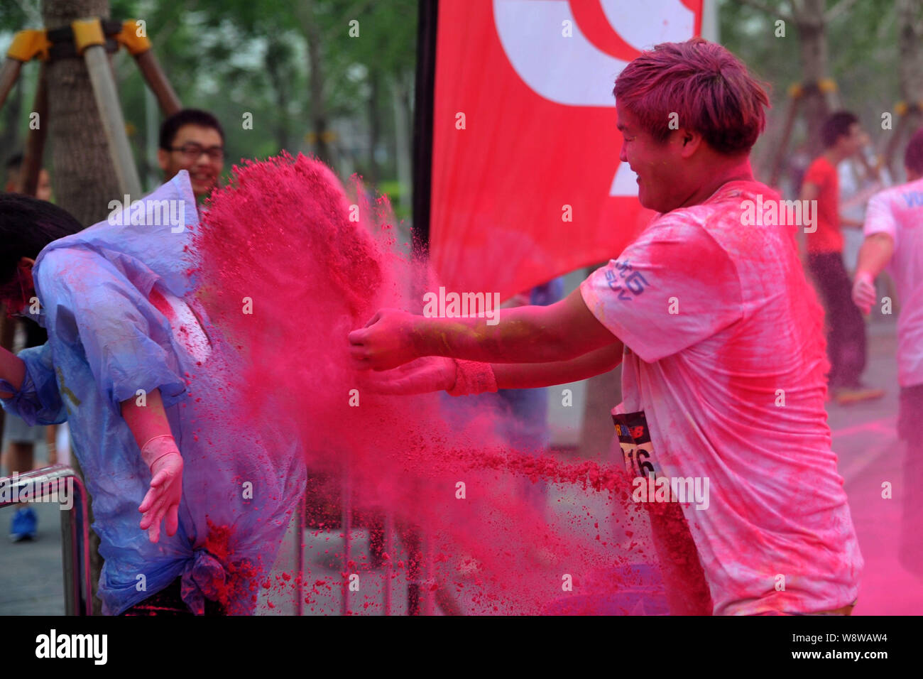Ein Mitarbeiter wird von einem Teilnehmer mit farbigem Pulver während der fünf Kilometer langen Colour run Ereignis in Peking, China, 21. Juni 2014 gesprüht. Über 10,0 Stockfoto