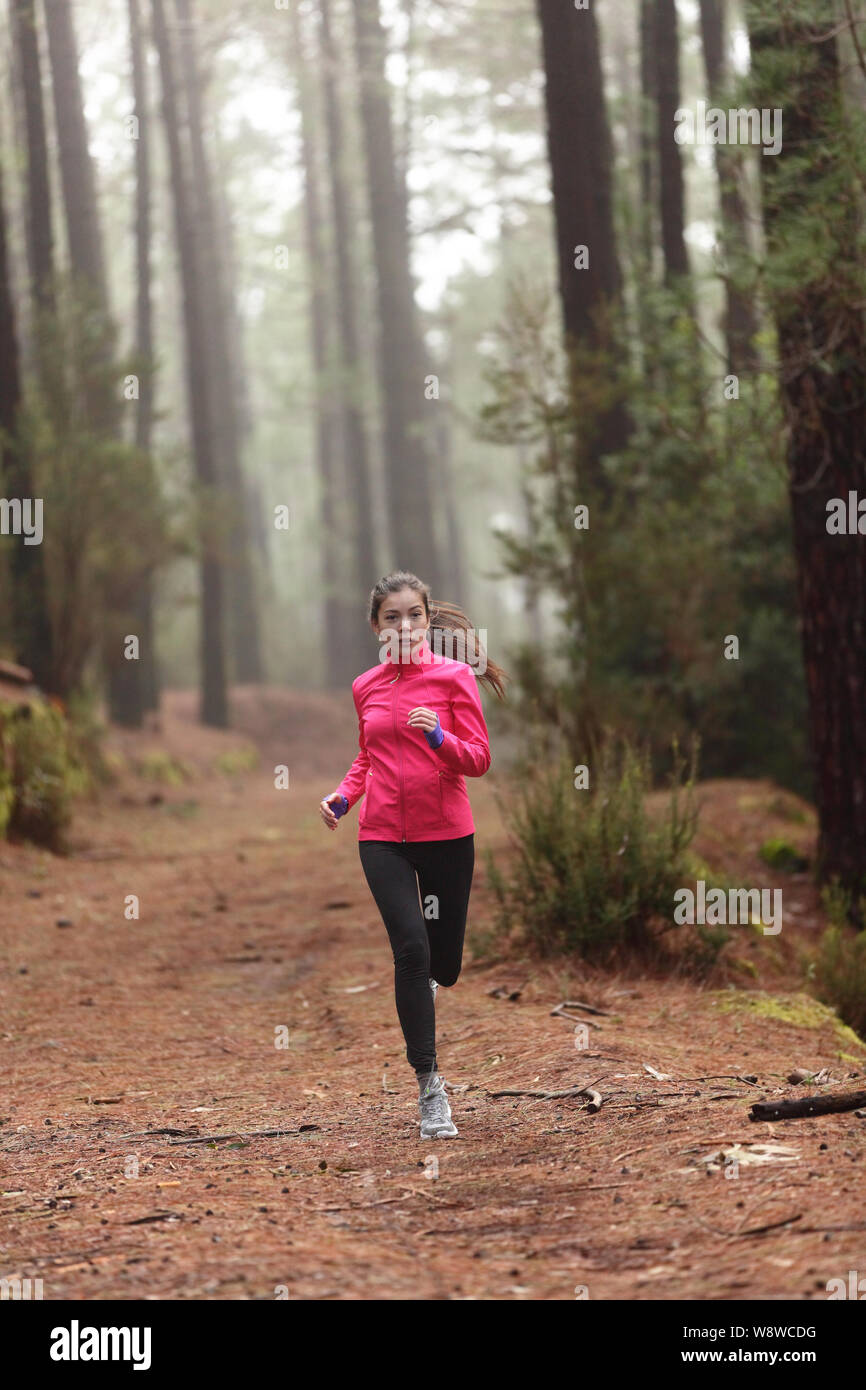 Läuft Frau im Wald Holz Schulung und Training für Trail laufen Marathon Endurance Rennen. Fitness gesunder Lebensstil Konzept mit weiblichen Athleten Trail Runner. Stockfoto
