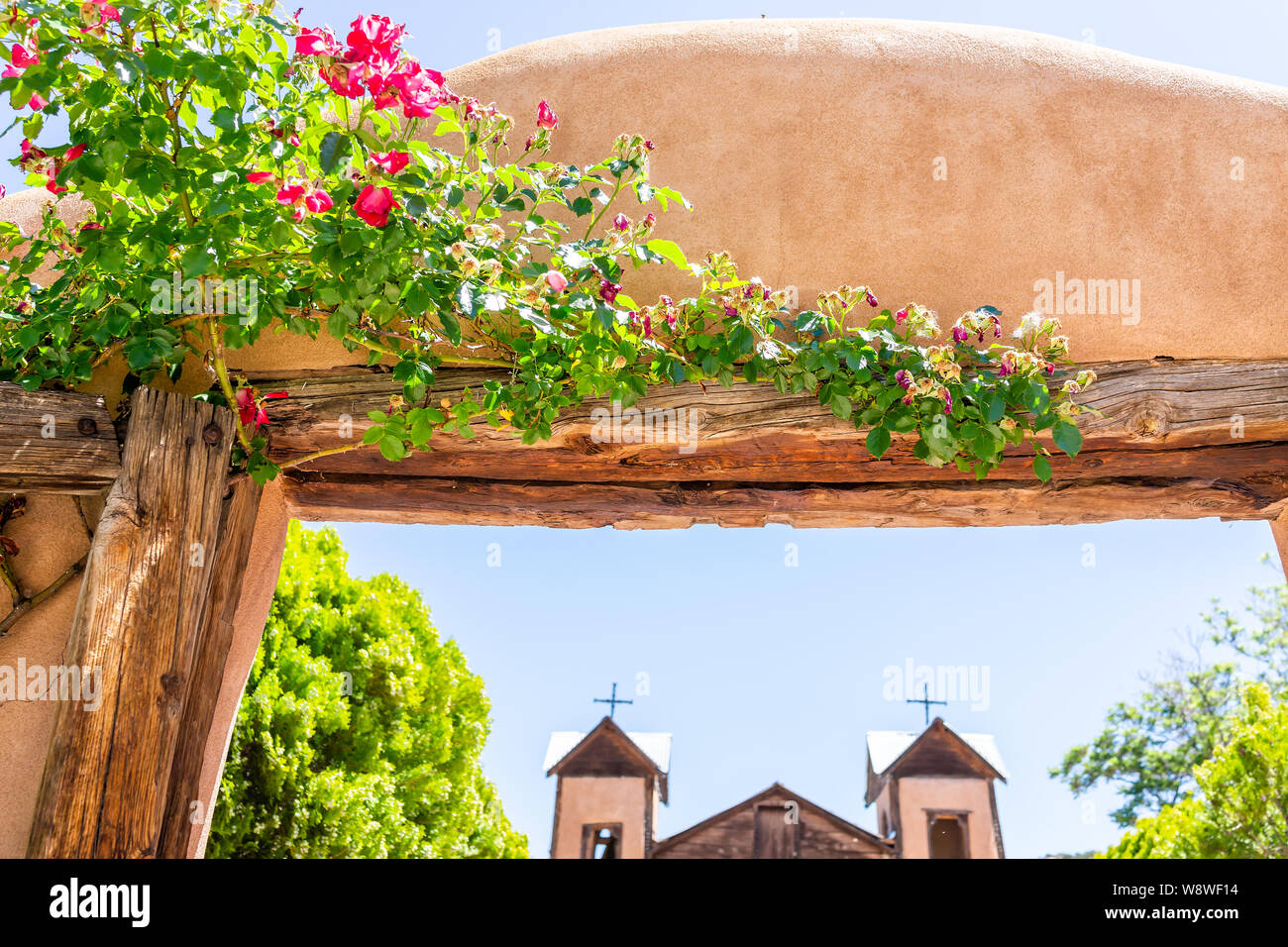 Berühmte El Santuario De Chimayo Heiligtum der Kirche in den Vereinigten Staaten mit Eingangstor Nahaufnahme von Blumen im Sommer Stockfoto