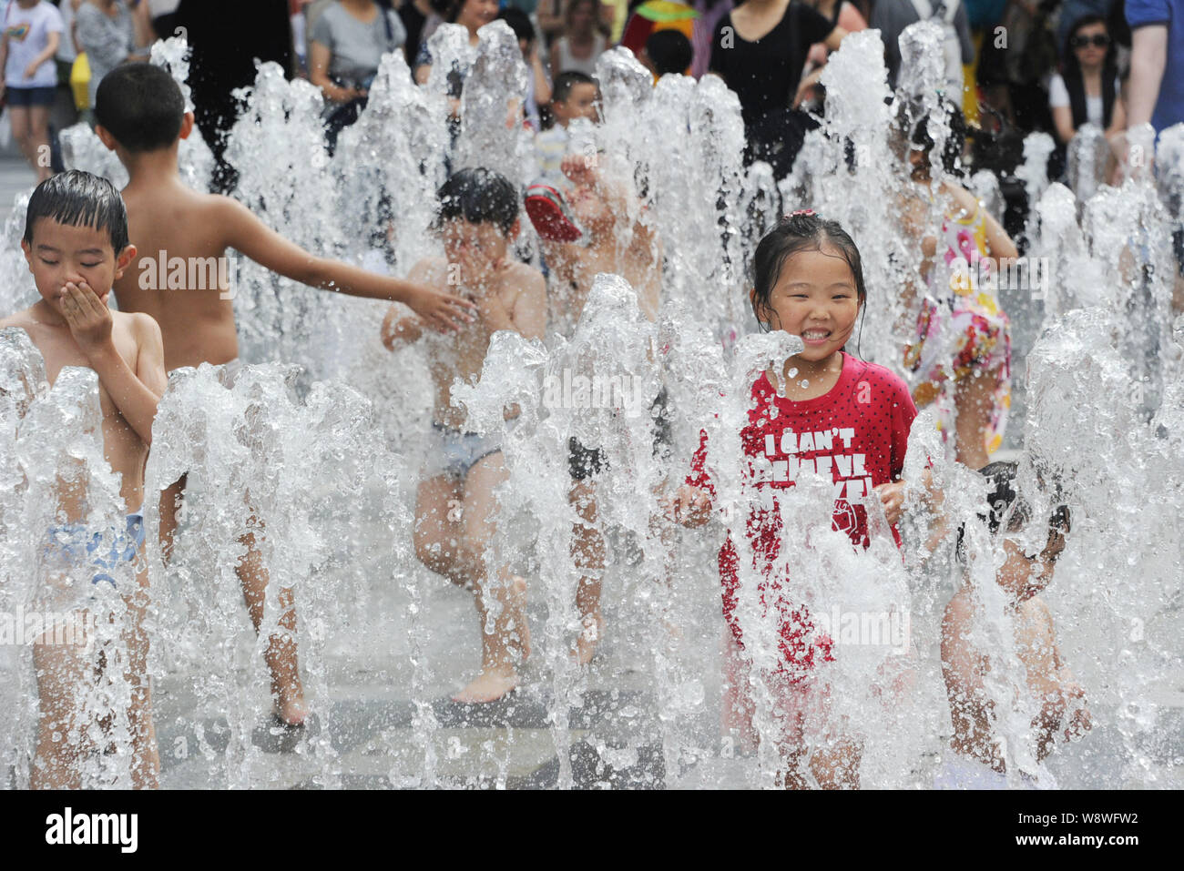 Chinesische Kinder spielen mit Wasser aus einem Brunnen auf einen heißen Tag in Shanghai, China, 19. Juli 2014 zu kühlen. Letzten Monat war die Welten heißesten J Stockfoto