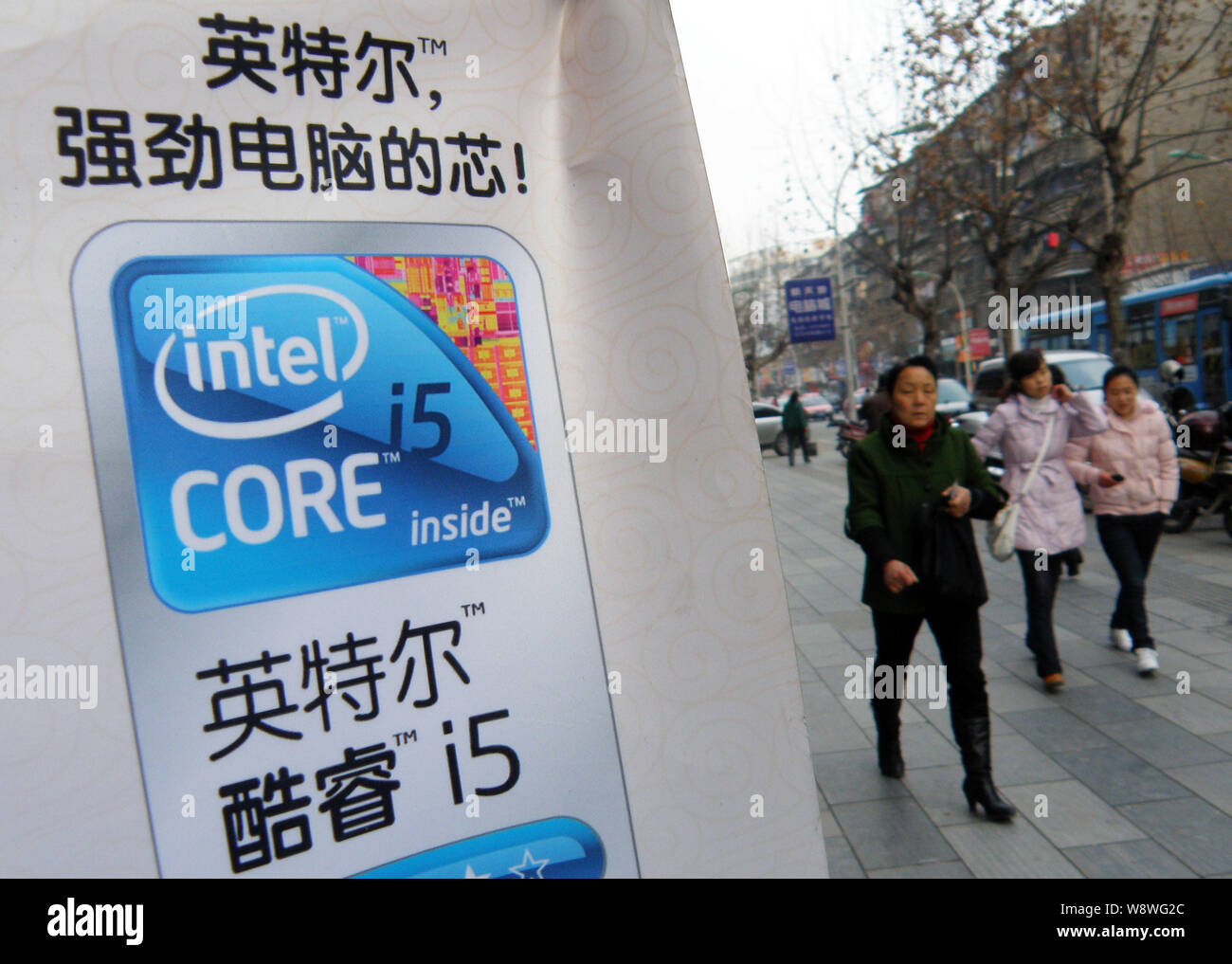 ---- Fußgänger vorbei an einem Plakat für Intel Core i5 im zentralen China Yichang, Provinz Hubei, 13. Februar 2011. US-Chiphersteller Intel hofft Stockfoto