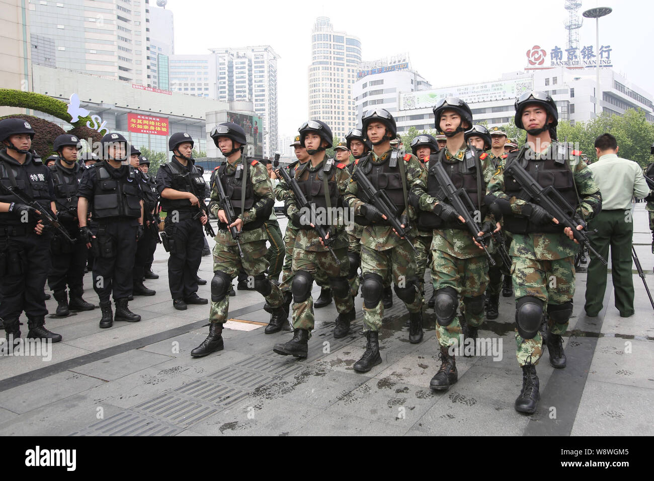 SWAT-Polizisten mit Gewehren bewaffnete Patrouille mit dem Quadrat der Bahnhof Shanghai in Shanghai, China, 14. Mai 2014. SWAT Polizei und andere Arm Stockfoto