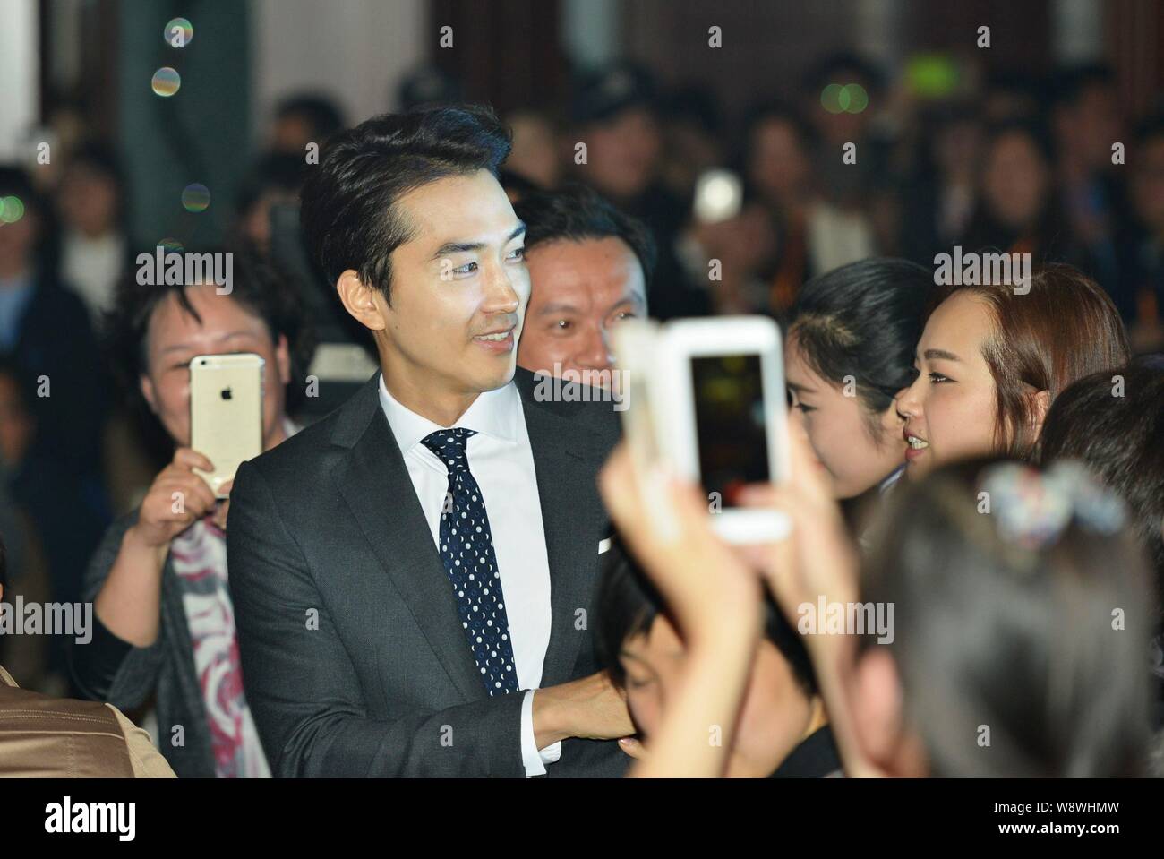 Koreanische Schauspieler Song Seung-heon, Mitte, wird von Fans umgeben, wie er für die 2014 China-Korea kulturellen Austausch Forum in Hangzhou city ankommt, Eas Stockfoto