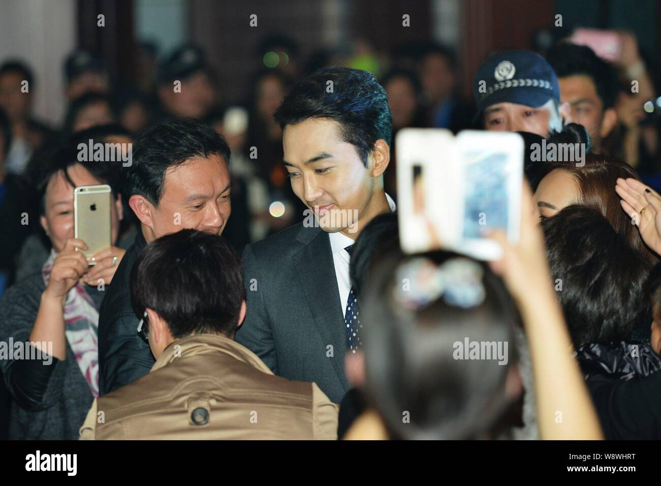 Koreanische Schauspieler Song Seung-heon, Mitte, wird von Fans umgeben, wie er für die 2014 China-Korea kulturellen Austausch Forum in Hangzhou city ankommt, Eas Stockfoto