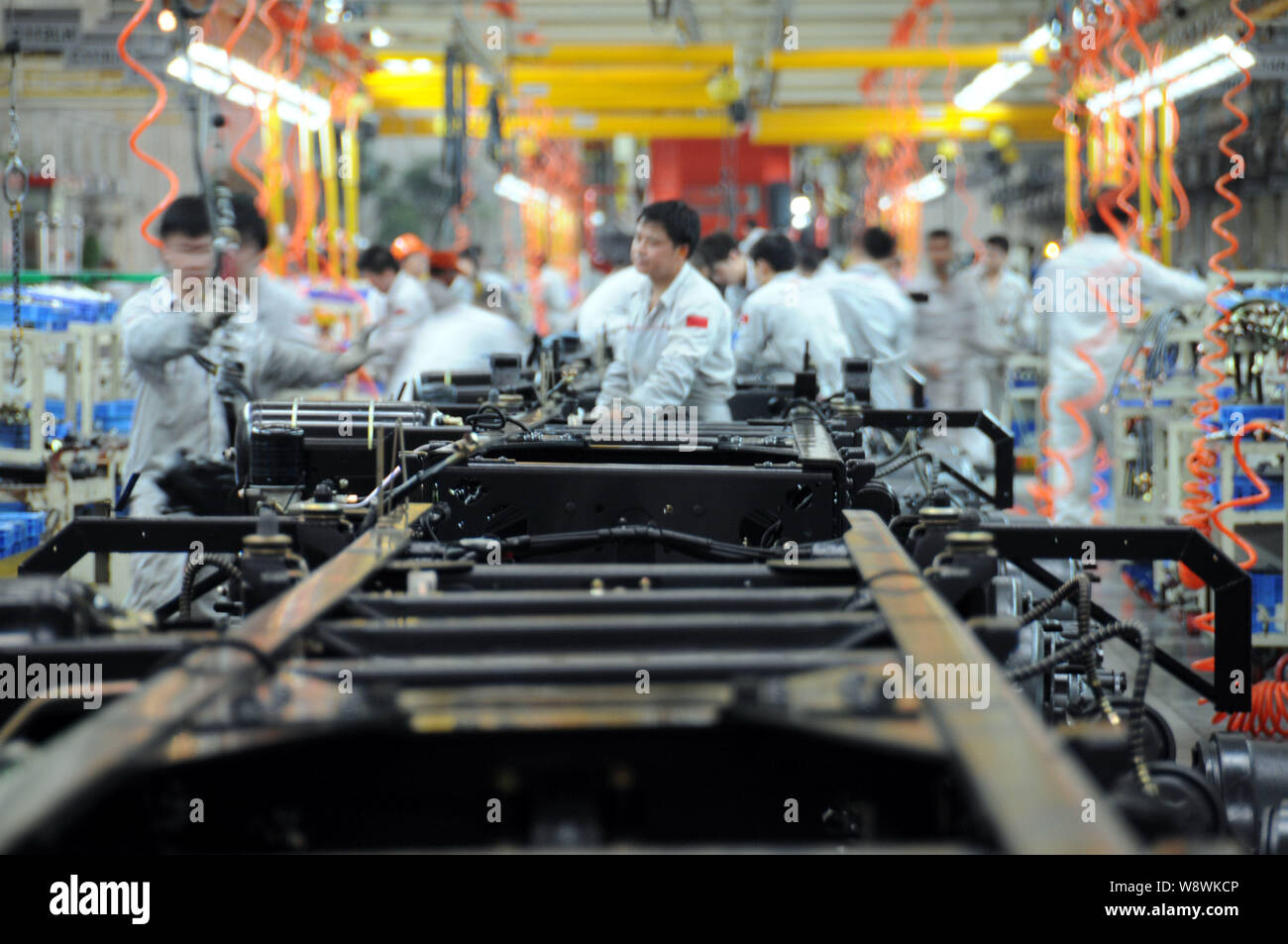 ------ Chinesische Arbeiter bereiten Teile in der Fertigung von schweren Lkw auf eine automatische Anlage von Dongfeng Nutzfahrzeug Co.in der bezirksfreien Stadt, zentrale Stockfoto