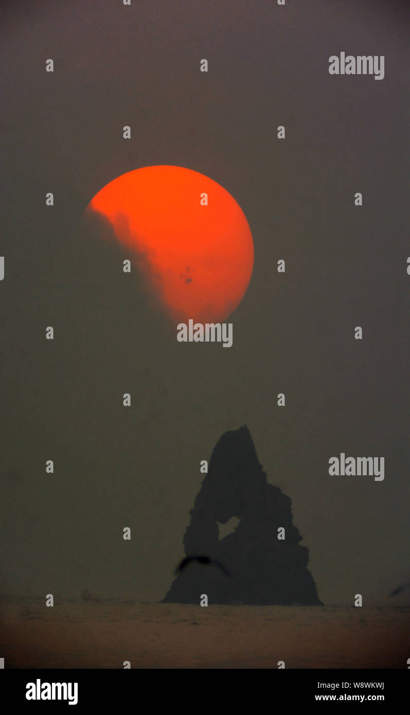 Große Sonnenflecken auf der Oberfläche der Sonne bei Sonnenuntergang in Qingdao Stadt gesehen, der ostchinesischen Provinz Shandong, 22. Oktober 2014. Die Astronomen haben spotte Stockfoto