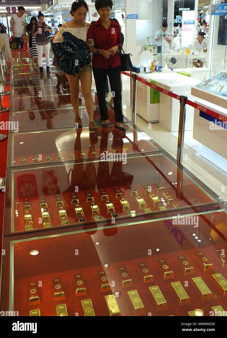 Kunden Spaziergang auf einem Gehweg aus 606 Gold Backsteine bei einem Einkaufszentrum in Yichang City, Central China Provinz Hubei, 21. September 2014. Stockfoto