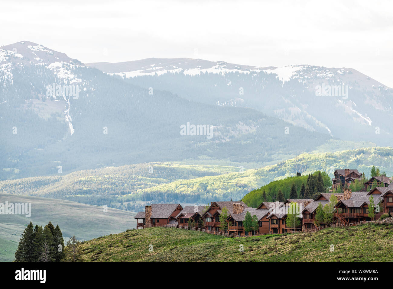 Mount Crested Butte Dorf in Colorado im Sommer mit sunrise von hölzernen Unterbringung Häuser auf den Hügeln mit grünen Bäumen, Stockfoto