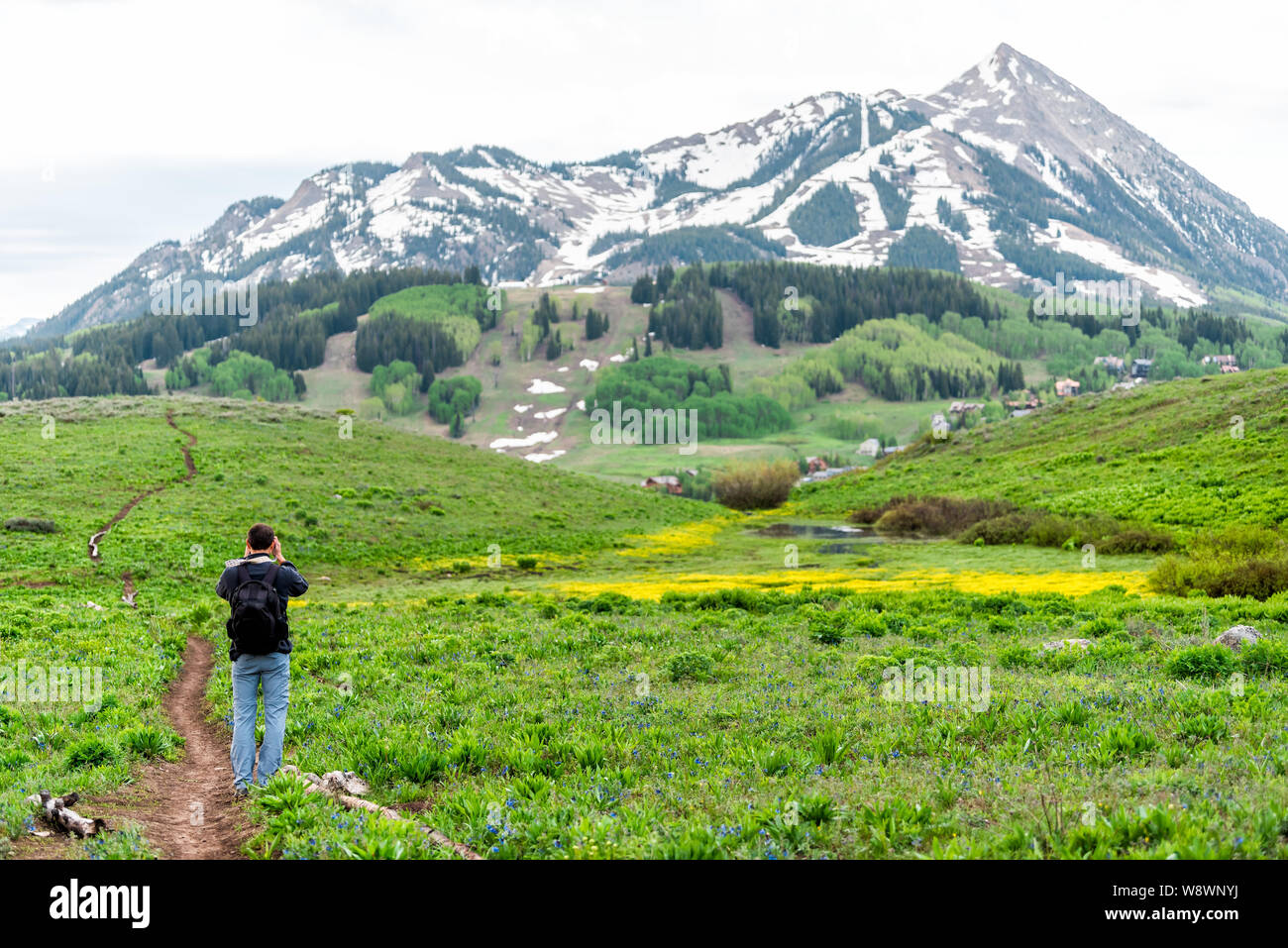 Mann stand unter Bild auf Snodgrass Trail mit Kamera und bokeh Hintergrund Blick auf Mount Crested Butte, Colorado peak Stockfoto