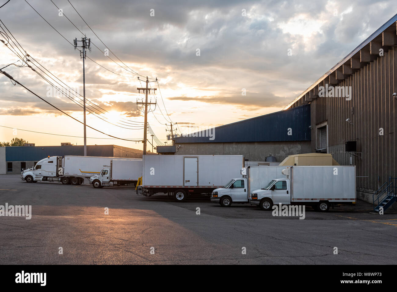 Geparkten Lkw und Transportern vor einem kleinen Geschäft Gebäude Stockfoto