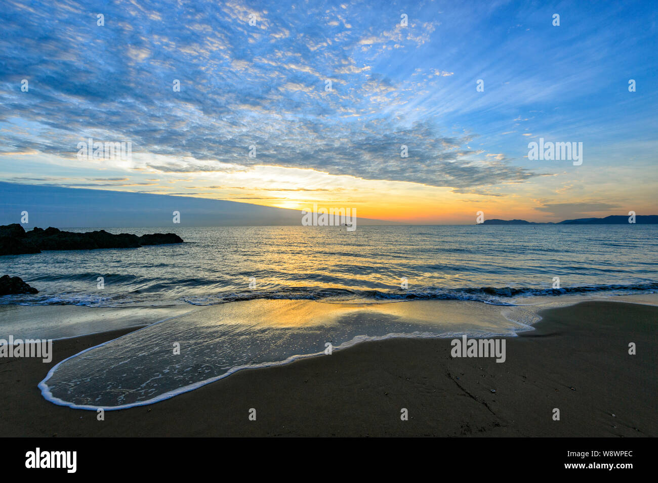 Atmosphärische sunrise mit kleinen Wellen an yorkey der Knopf, Cairns Northern Beaches, Far North Queensland, FNQ, QLD, Australien Läppen Stockfoto