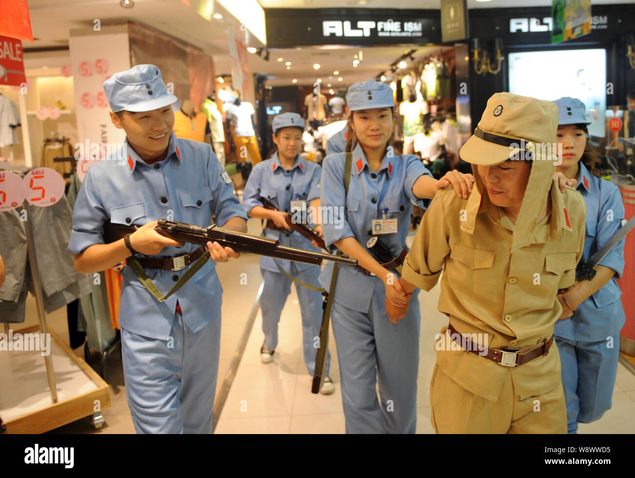 Chinesische Beamte in blauen Uniformen des 8. Route Armee escort ein Mitarbeiter in einer Uniform der japanischen Armee während des Zweiten Weltkriegs bekleidet gekleidet, Stockfoto