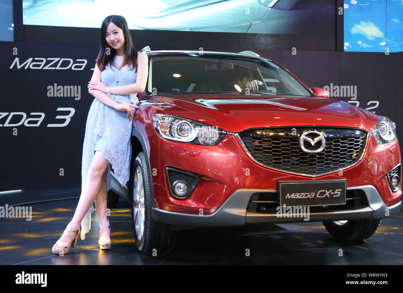 ---- Ein Modell wirft mit Mazda CX-5 bei einem Automobil Ausstellung in Zhengzhou City, Central China Provinz Henan, 6. November 2013. Mazda Motor Stockfoto