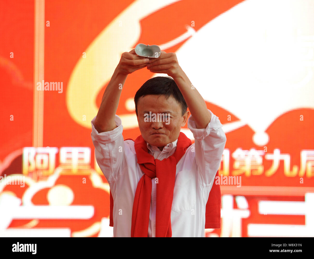 Jack Ma Yun, Vorsitzender der Alibaba Group, macht ein Trankopfer seinen Segen für die Paare während einer Hochzeit in der Zentrale der liefern Stockfoto