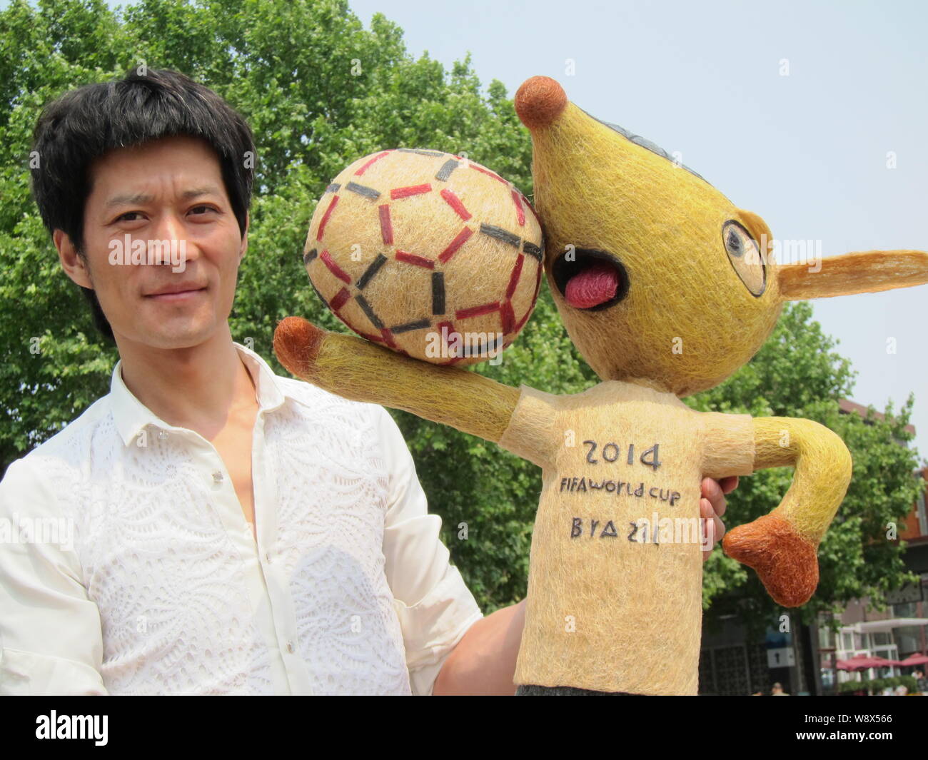 Chinesische hairstylist Huang Xin stellt mit seinem Haar - Fuleco, das Maskottchen der FIFA WM 2014 in Brasilien, in Peking, China, 8. Mai 2014. Ein Chines Stockfoto