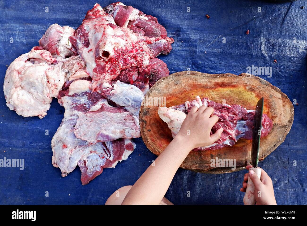 Oberwinkelaufnahme der Hände, die das Kuhfleisch hacken. Stockfoto