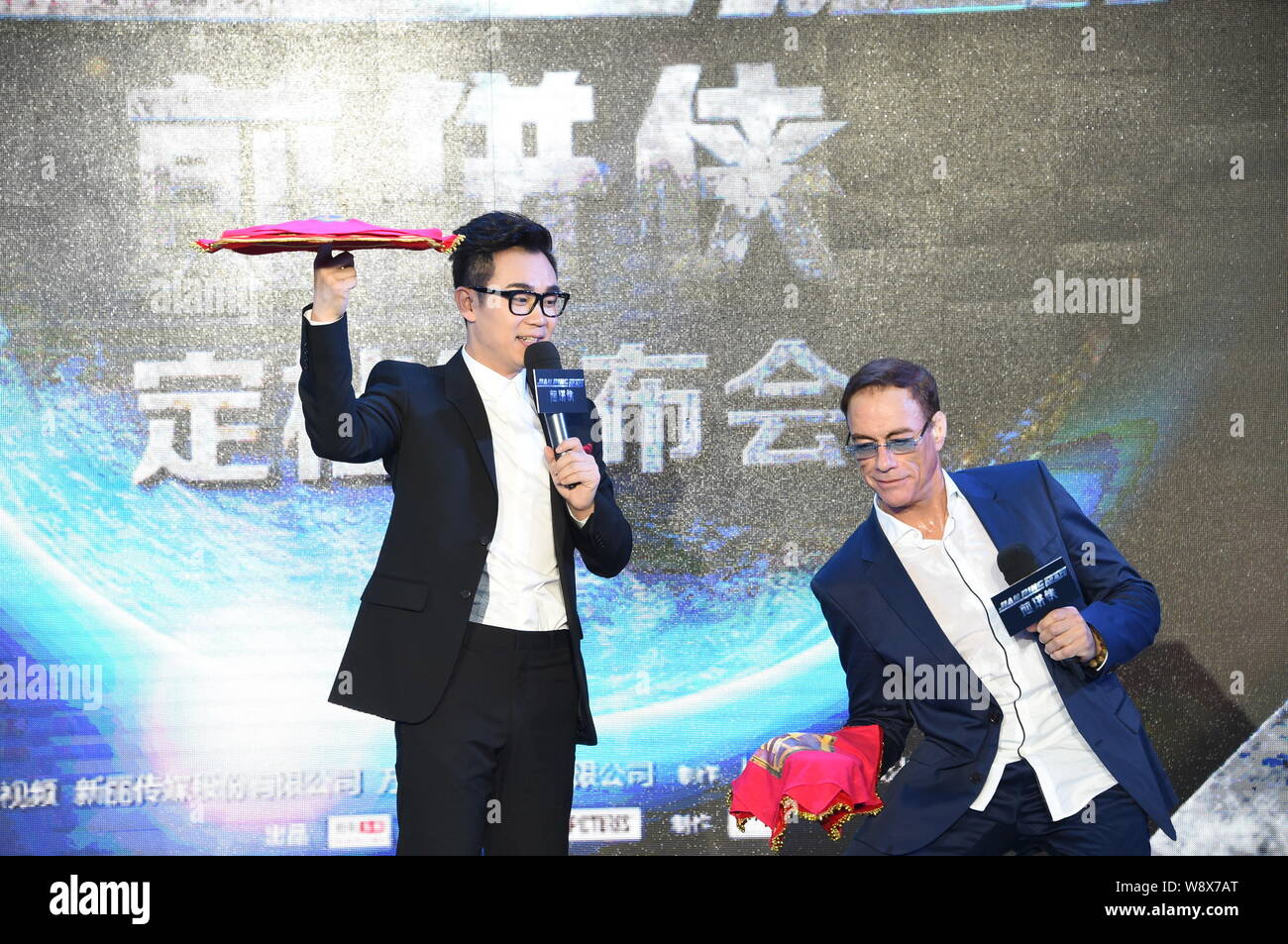 Usa Hollywood action star Jean-Claude Van Damme, rechts, dreht sich ein Taschentuch während einer Pressekonferenz für den Film "Der Pancake Man' in Peking, Stockfoto