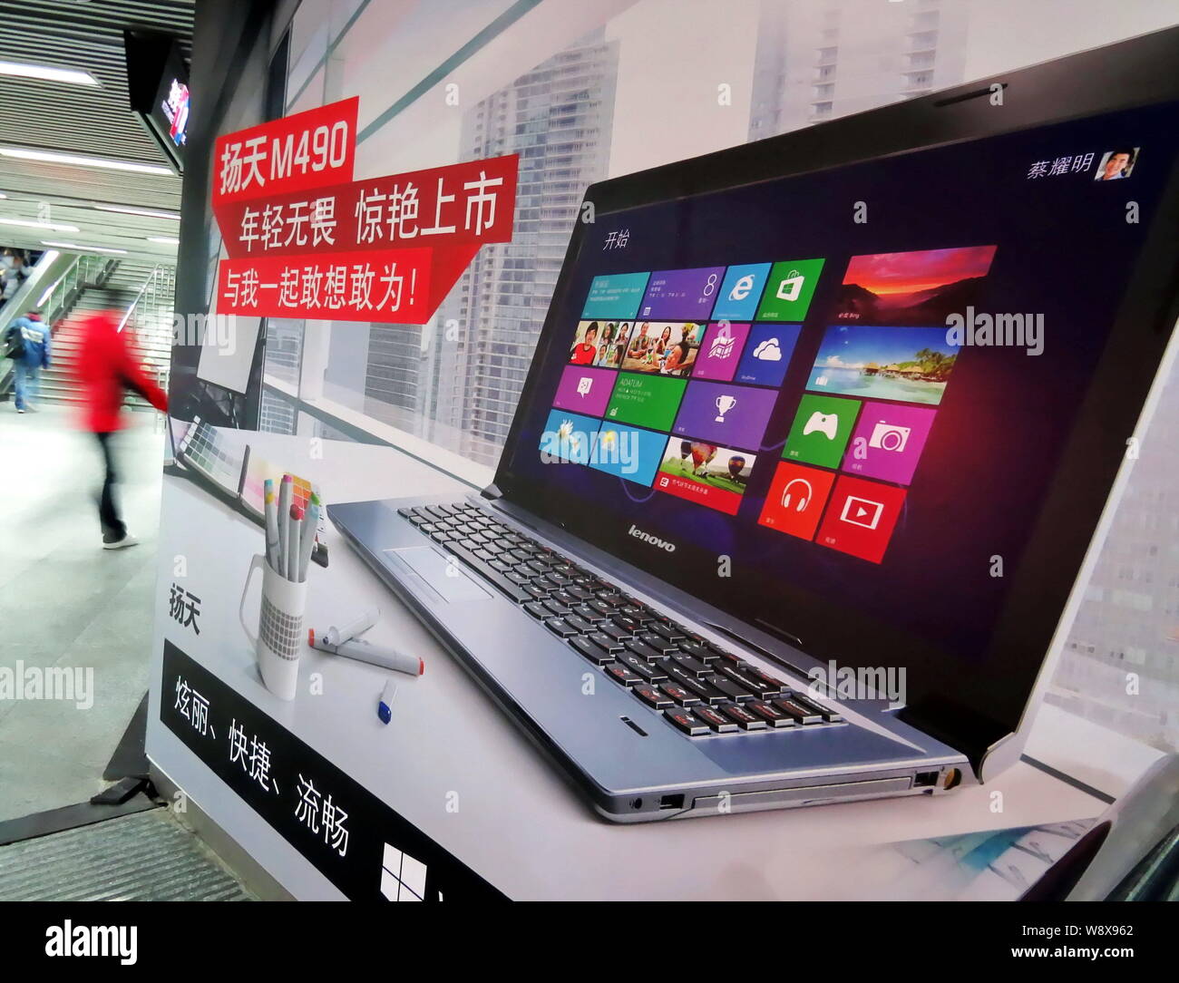 ---- Einen Fußgänger an einer Werbung für Lenovo Laptops an einer U-Bahn-Station in Shanghai, China, 27. Januar 2013. Lenovo Group Lt Stockfoto