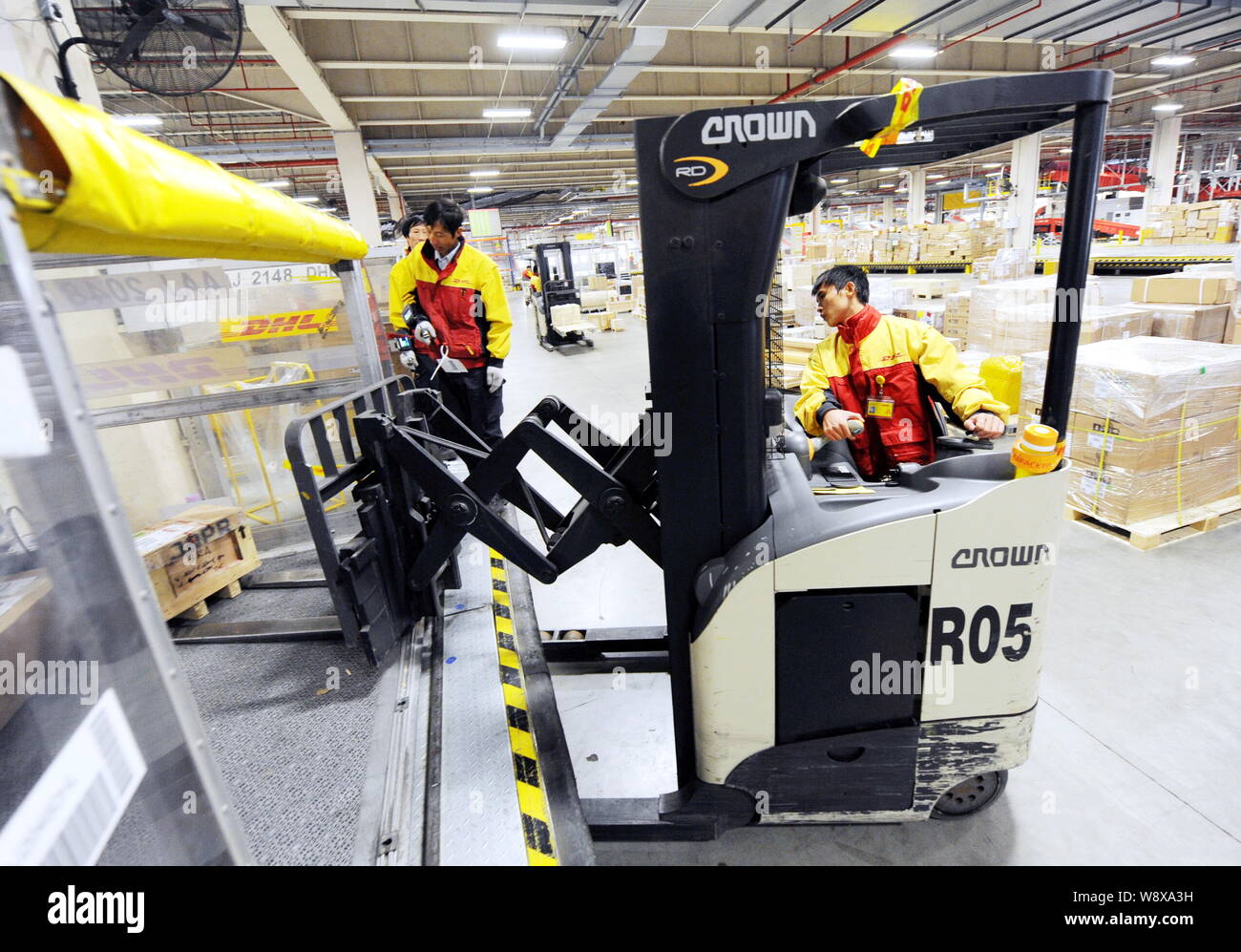 ------ Chinesische Arbeiter Pakete in einen Behälter für die Sammlung und tranfer Lager von DHL am Flughafen Shanghai Pudong Free Trade Zone in Stockfoto