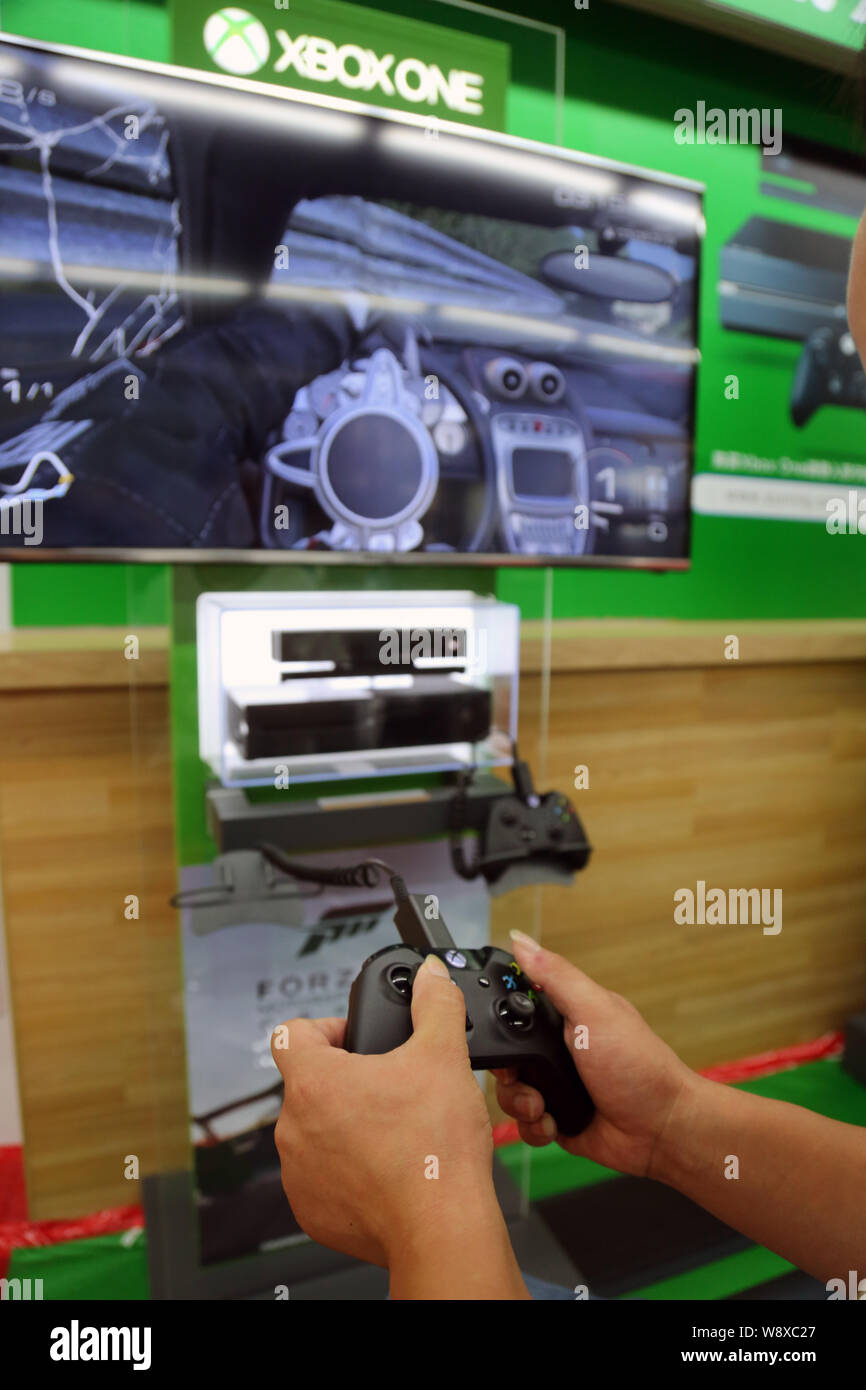 Einen Kunden spielt elektronische Spiele auf einer Xbox eine Spielkonsole zu einem suning Haushaltsgeräte in Shanghai, China, 29. September 2014. Microsoft la Stockfoto