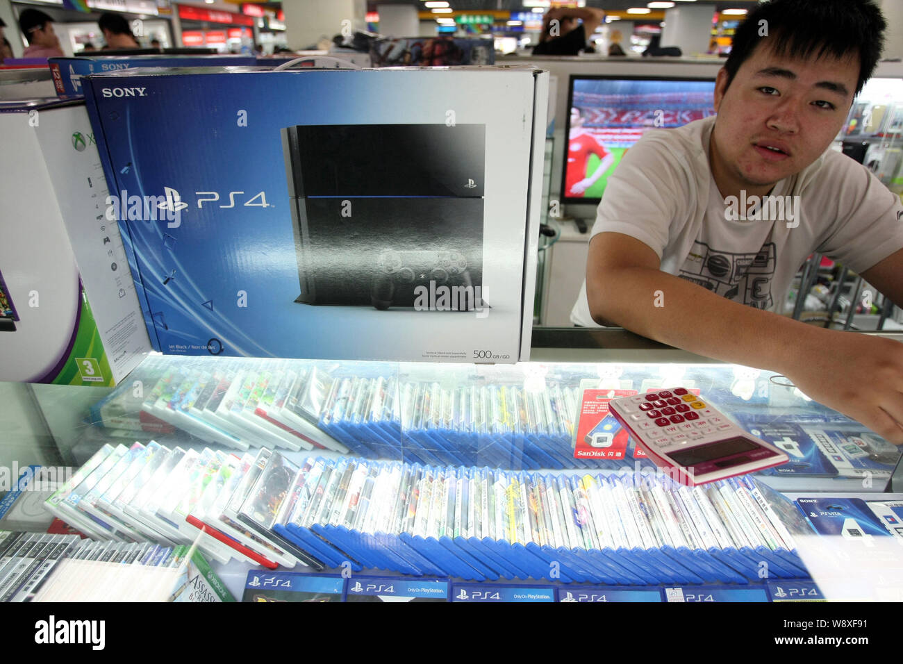 Ein chinesischer Hersteller sieht neben einem geschmuggelt Sony PlayStation  4 (PS4) Spiel Konsole zum Verkauf an einer digitalen Produkte Mall in  Shanghai, China, 29. Mai 2014 Stockfotografie - Alamy